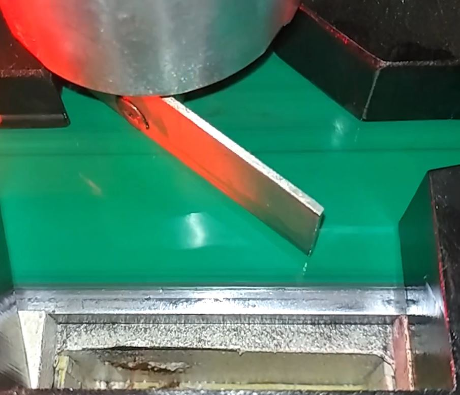 The powered flipper diverts rejected rollers into the chute.