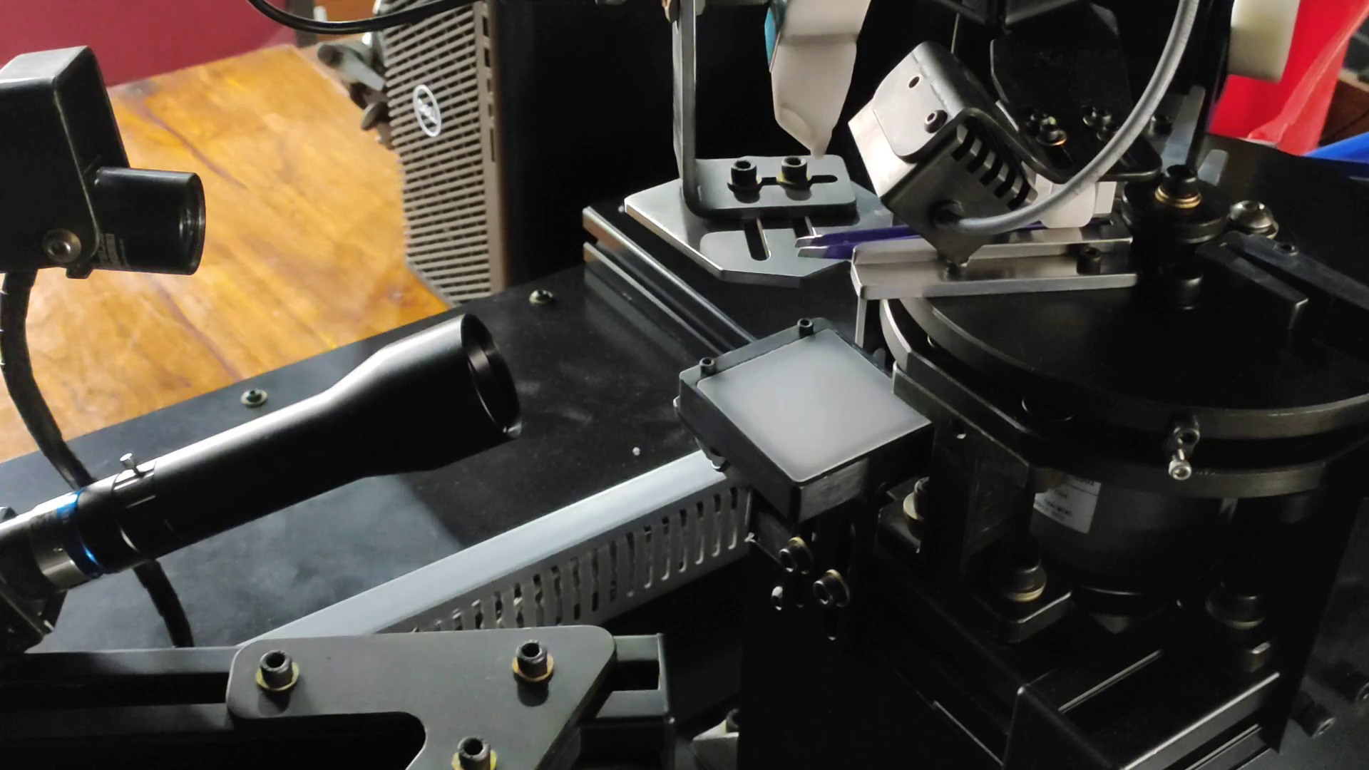Camera optics and controlled closing mechanism beside the rotating tweezer fixture